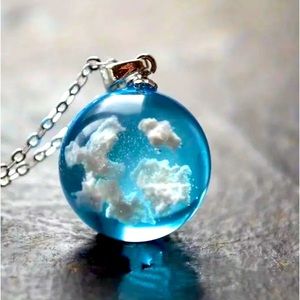 copy—This pendant necklace, blue with white clouds and on silver